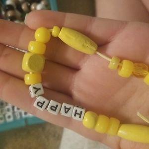 Yellow bracelet that says happy!